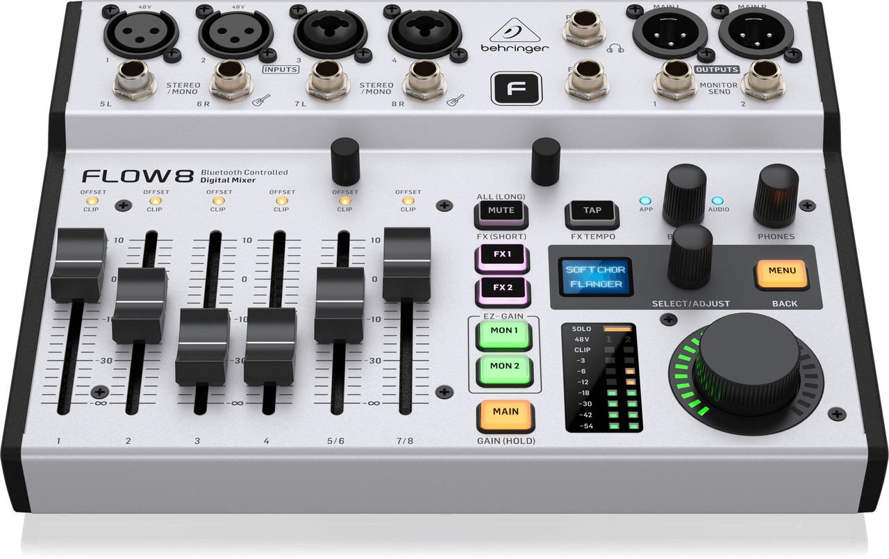 A home music studio desk with a mixing console and headphones in warm light